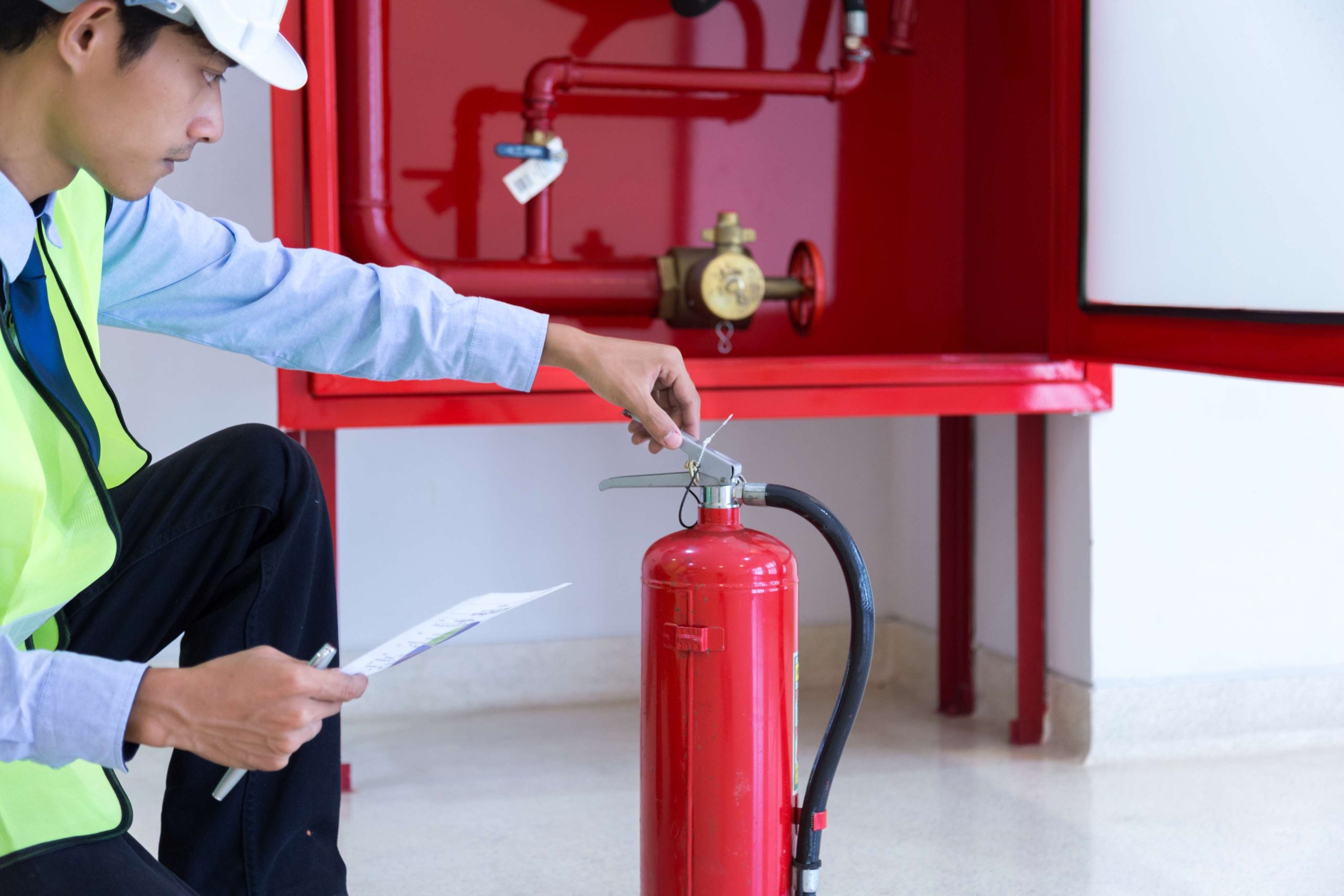 side view technician examining fire extinguisher